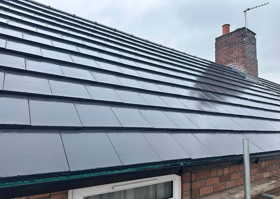 A newly tiled roof with a brick chimney stack