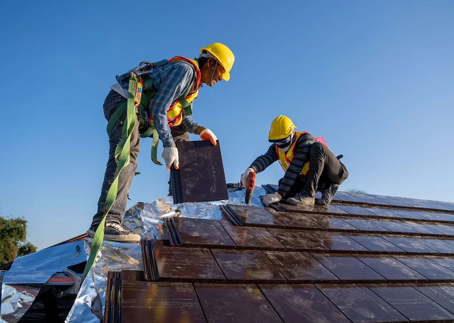 Roofers laying new tiles on a pitched roof