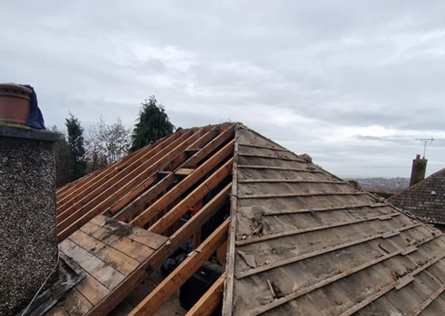 Close-up of a roofer replacing tiles on a pitched roof